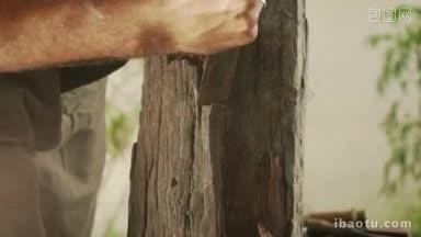 男雕刻家正在用锤子和凿子清理一块未加工的木块